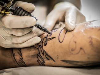 tatoueur qui réalise un tatouage