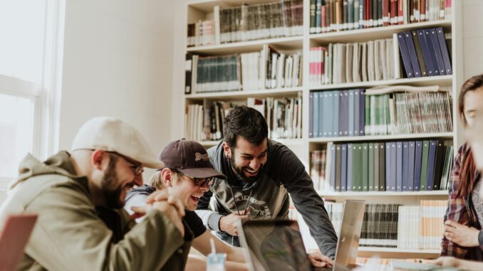 Photo by Priscilla Du Preez 🇨🇦 three men laughing while looking in the laptop inside room